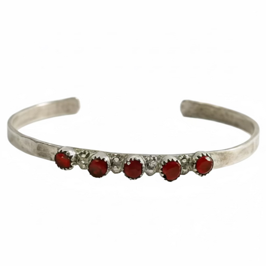 Silver bracelet with red stones on a white background