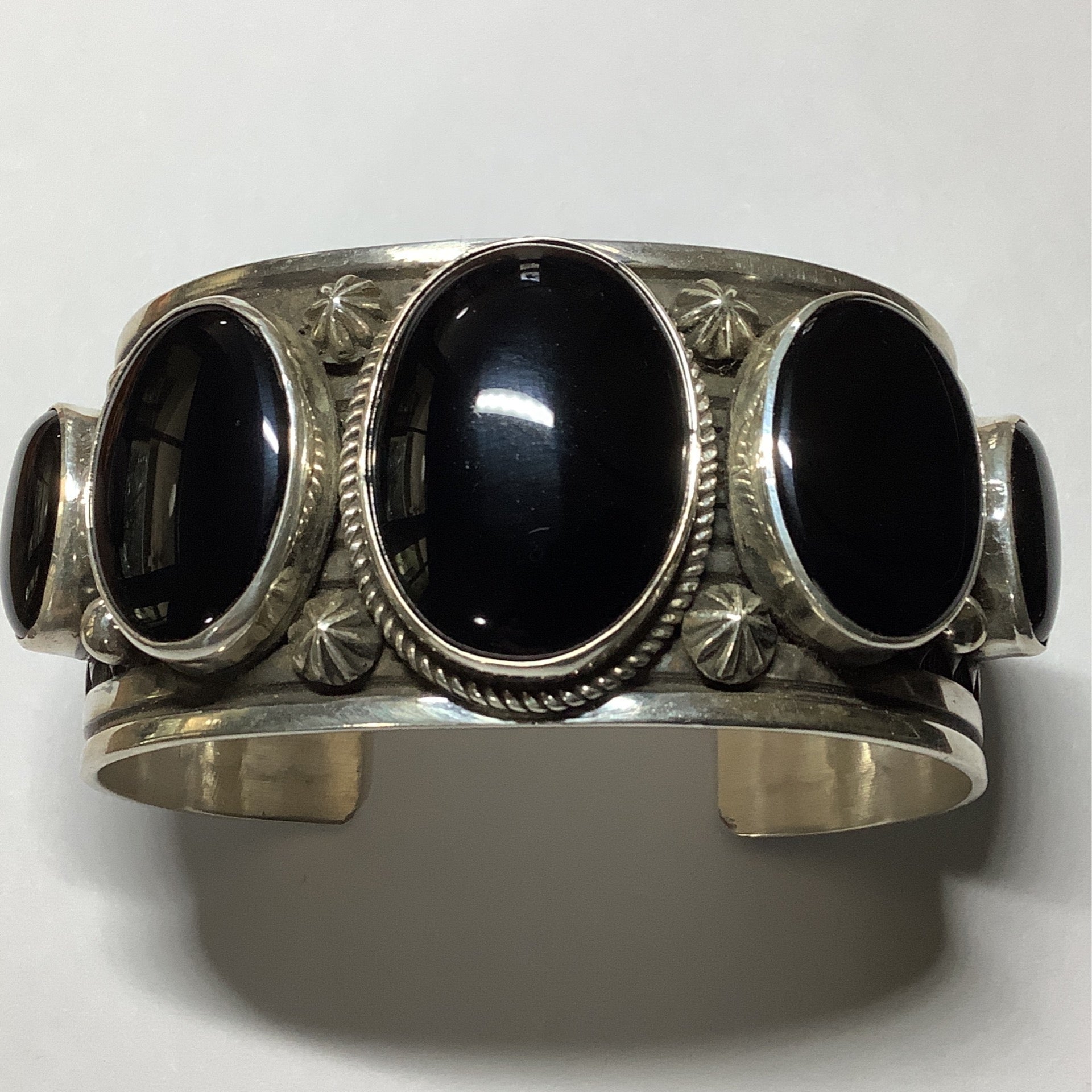 Bracelet, 5 oval Onyx stones, 9 rows of stamp work, rope bezel on center, four cactus buttons, Albert Jake crafted from Sterling Silver, an exquisite Bracelets Native America designed by Turquoise Mustang.