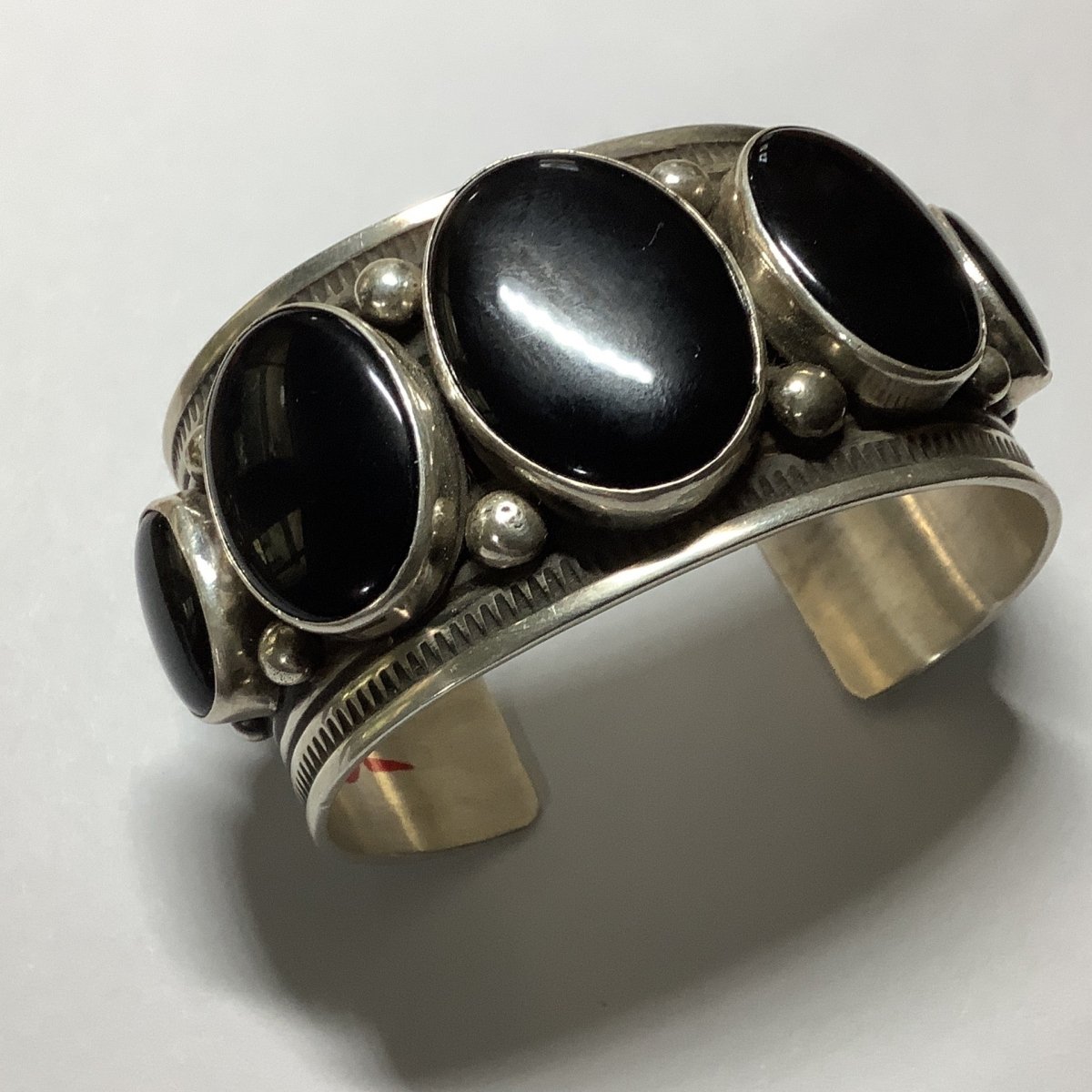 Bracelet, 5 oval Onyx stones, 9 rows of stamp work, raindrops, four peyote buttons on side, by Albert Jake - Turquoise Mustang